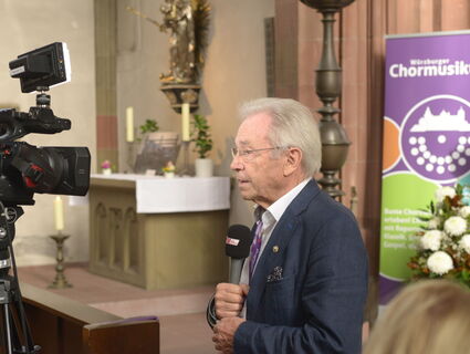 Alois Henn spricht in eine Fernsehkamera